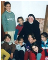 Foto en color de niños en Escuelas Puente con una monja