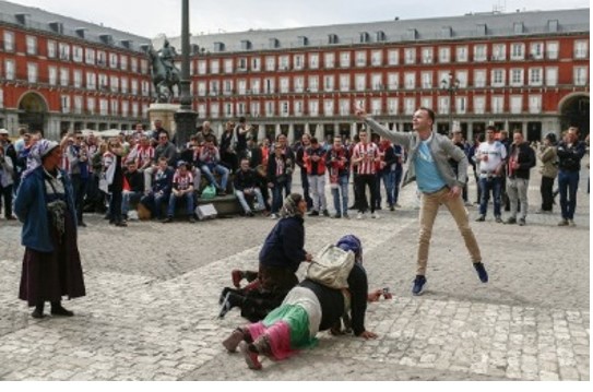 foto de El País donde unos aficionados vejan a unas mujeres gitanas