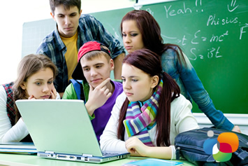 Adolescentes en clase mirando un ordenador